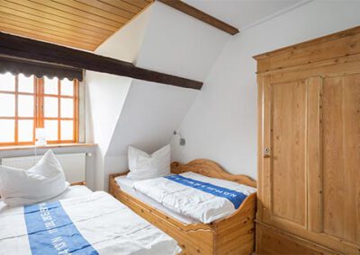 Schlafzimmer mit zwei Einzelbetten in der Ferienwohnung F4 Haubarg & Remise St. Peter-Ording