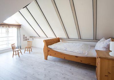 Schlafzimmer mit Einzelbett in der Ferienwohnung F 6 Haubarg & Remise St. Peter-Ording