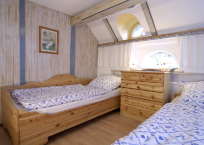 Schlafzimmer mit zwei Betten in der Ferienwohnung Haubarg F2 - Haubarg & Remise St. Peter-Ording