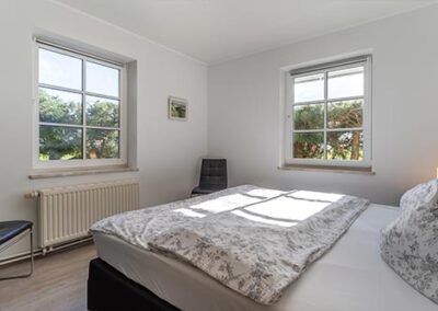 Schlafzimmer mit zwei Doppelbetten in der Ferienwohnung R1 Haubarg & Remise St. Peter-Ording