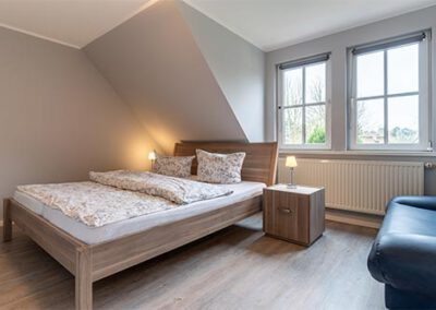 Schlafzimmer mit Doppelbett in der Ferienwohnung R3 Haubarg & Remise St. Peter-Ording